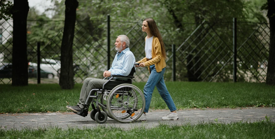 Доглядальниця гуляє з літньою людиною